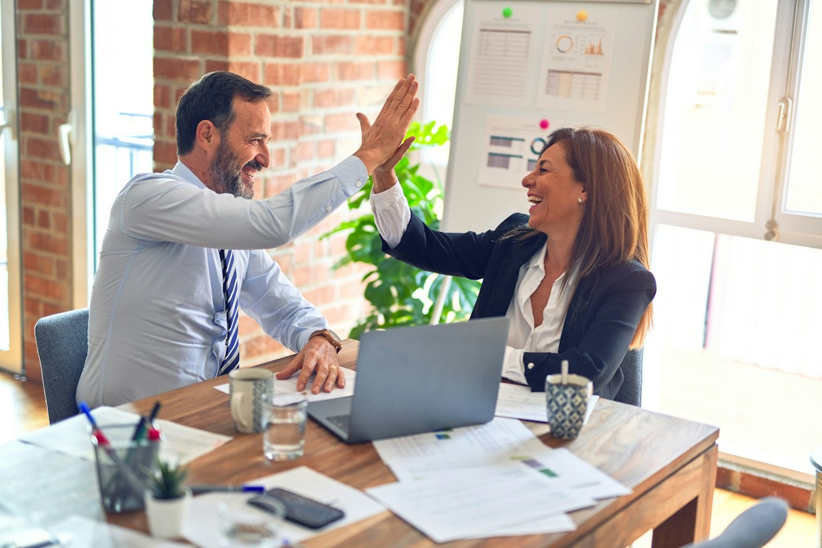 Two colleagues agreeing a plan across a desk