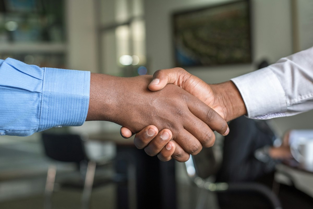 Two people sealing a partnership with a handshake